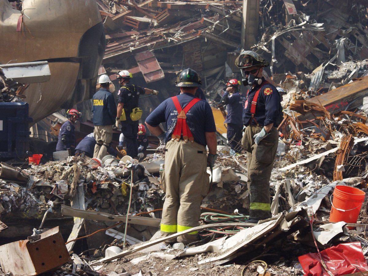 The wreckage of the World Trade Center site with recovery crews and heavy equipment working among the debris