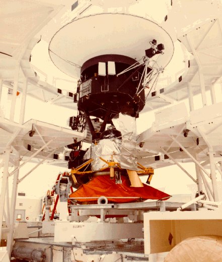 A Voyager spacecraft mounted on its support fixture inside a clean-room facility before launch